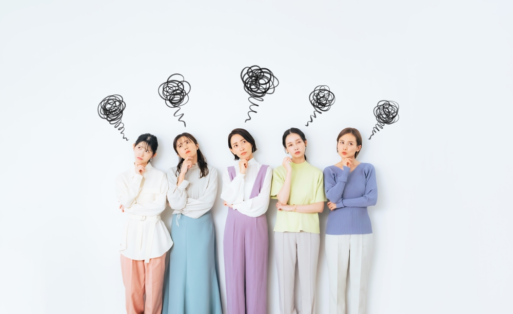 悩んでいる女性たちの画像。頭の上にモヤモヤマークを並べている